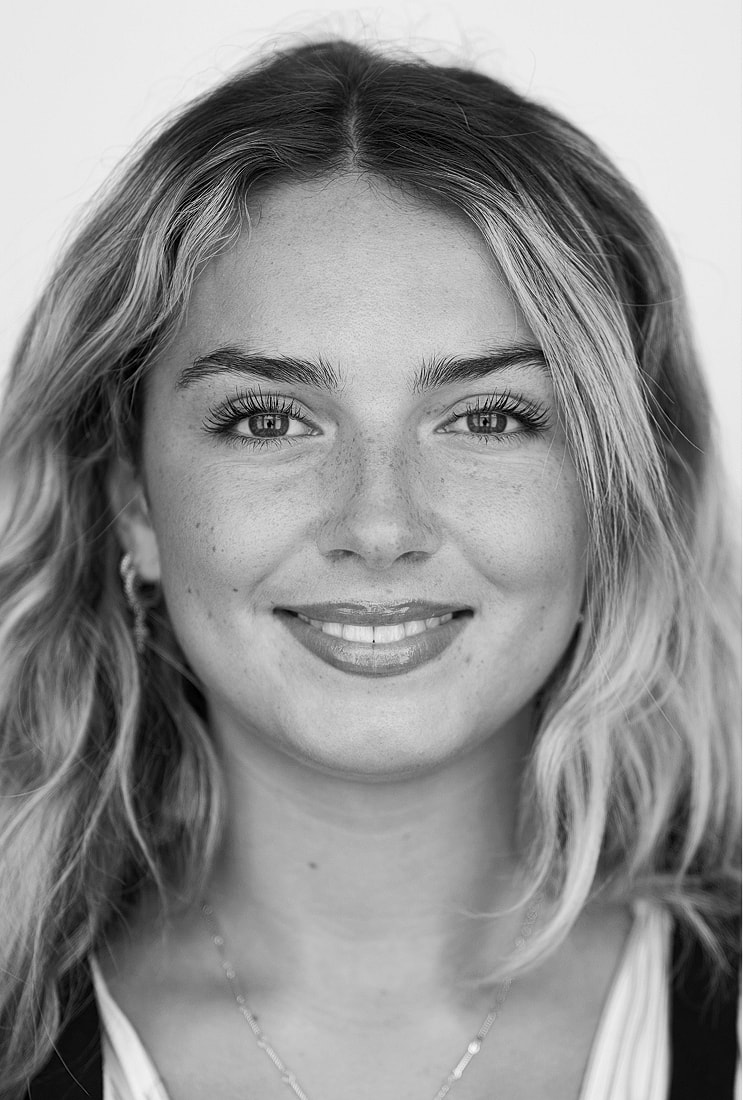 Smiling woman with wavy hair, black and white.