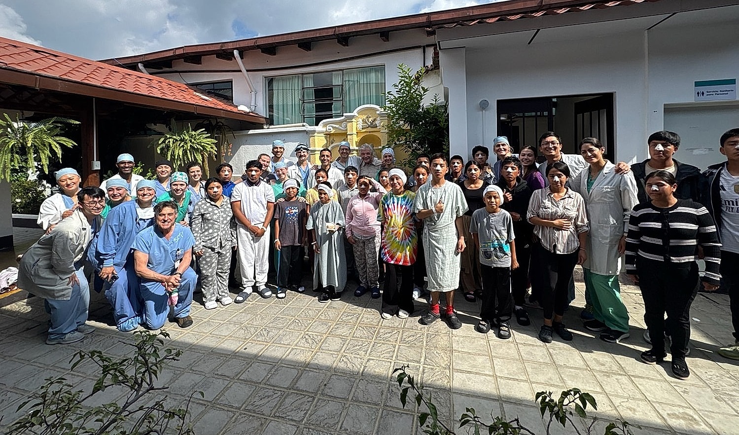 Group photo of medical staff and patients outside.