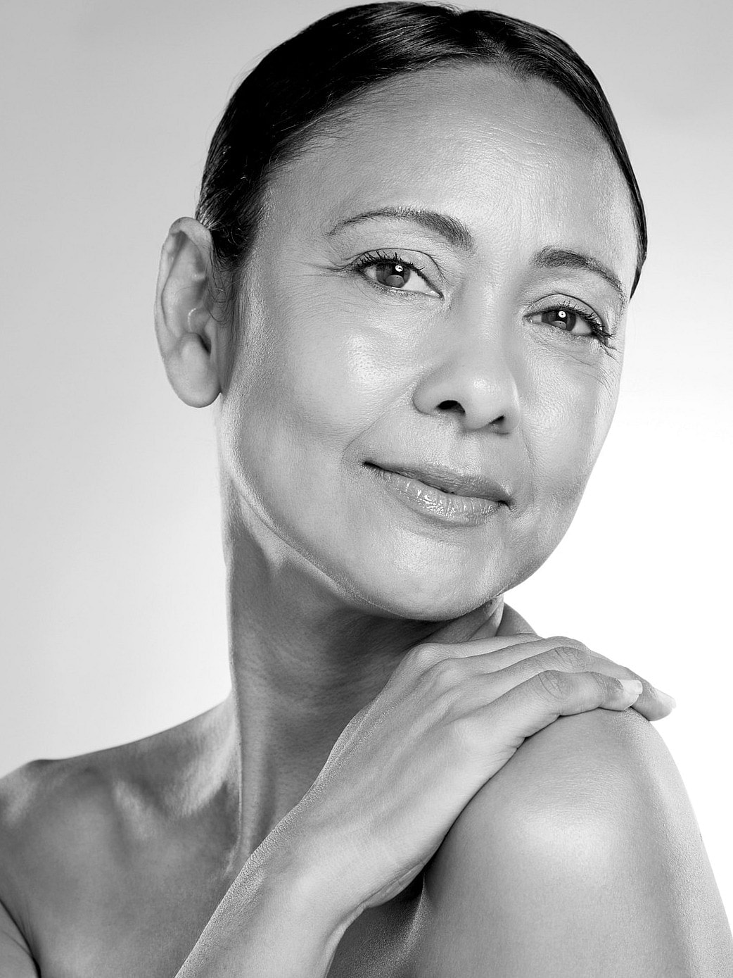 Black and white portrait of a smiling woman.