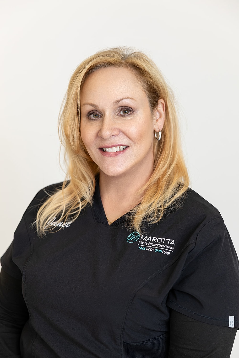 Female medical professional smiling in uniform.