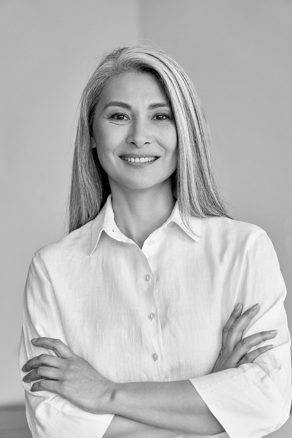 Smiling woman with long, straight gray hair.